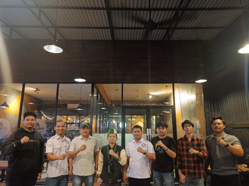 Personel Ditintelkam Polda Riau berfoto bersama pengurus HMI Badko Riau-Kepri, Rabu (23/10/2024) malam.