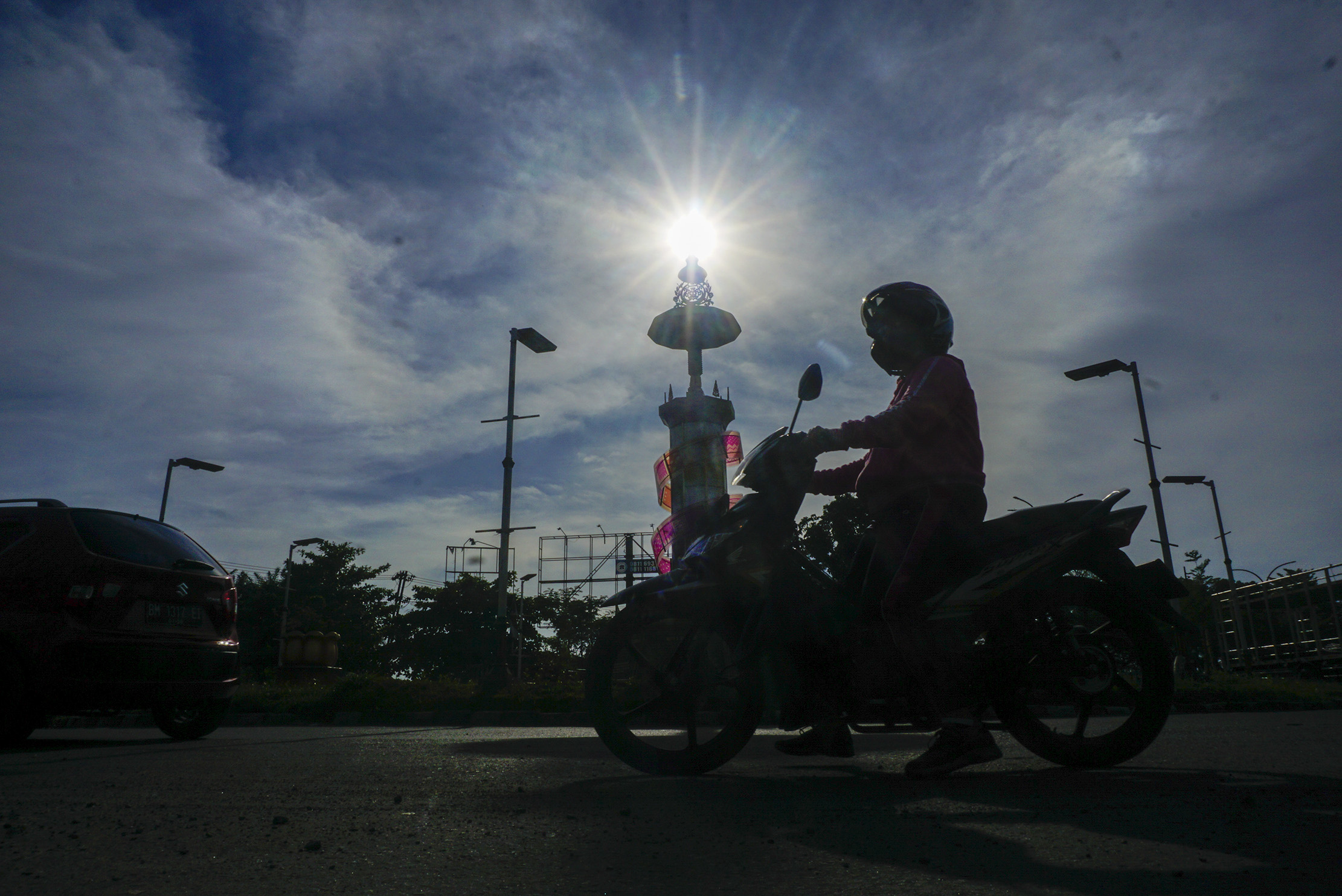 Paparan sinar matahari tepat diatas Tugu Songket ketika pengendara melintas di kawasan persimpangan tersebut, Pekanbaru, Jumat (25/10/2024) Kondisi Cuaca Pekanbaru yang panas hingga mencapai suhu 34 derjat celcius di siang hari. ft: MHD AKHWAN/RIAUPOS