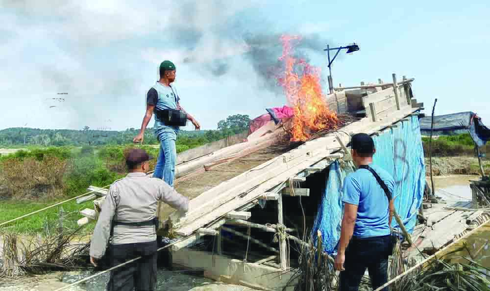 Polsek Singingi Hilir membakar rakit PETI yang ditemukan di Desa Sungai Paku, Kecamatan Singingi Hilir, Sabtu (26/10/2024).