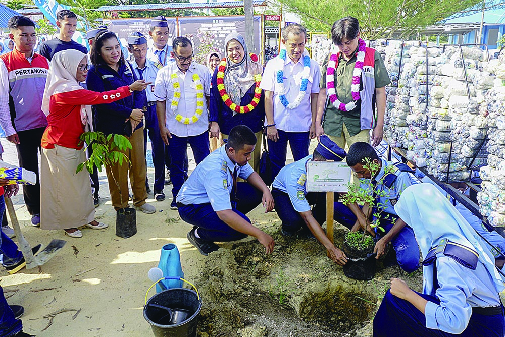 Perwakilan siswa melakukan penanaman pohon pelindung di lapangan sekolah di saksikan Kepala SMAN Bernas Binsus Ibu Tati Andriani (Dua Kiri), Dept Formalitas dan Komunikasi SKK Migas Sumbagut, Ibu Nora Asimah (Tiga Kiri), Direktur Riau Pos Asmawi Ibrahim,