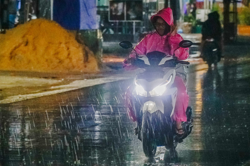 Pengendara sepeda motor menerobos guyuran hujan saat melintas di Jalan Cipta Karya, Kota Pekanbaru, Selasa (29/10/2024) malam.