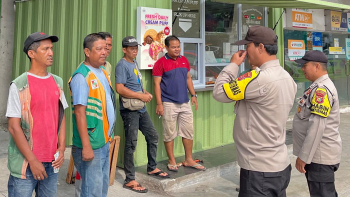 Personil Polsek Senapelan saat melaksanakan kegiatan cooling system salah satu kedai warga di depan pasar buah, Kelurahan Sago, Kecamatan Senapelan, Kota Pekanbaru, Ahad (03/11/2024).
