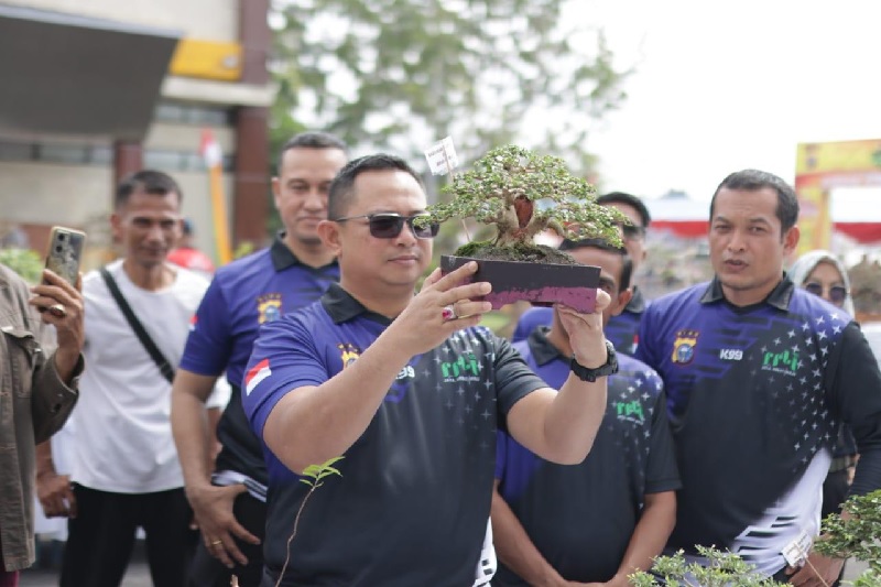 Kapolres Siak AKBP Asep Sujarwadi SIK MSI memperlihatkan bonsai dalam Kopdar Bonsai yang diikuti para pecinta bonsai dari berbagai daerah, serta bazar UMKM dan pasar murah di halaman Polres Siak,