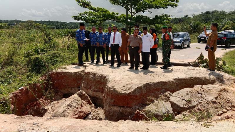 Pjs Bupati Kuansing drg Sri Sadono Mulyanto MHan (kiri) bersama Kadis PUPR Kuansing Zulkarnain meninjau jembatan darurat yang putus