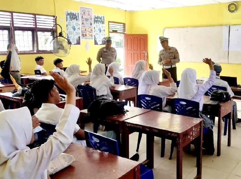Kanit Lantas Ipda Iwan Saputra SH MH, Banit Lantas Polsek Tandun Aipda Jon Piter memberikan edukasi kepada siswa saat giat Coolling System di SMAN 2 Tandun, Selasa (12/11/2024).
