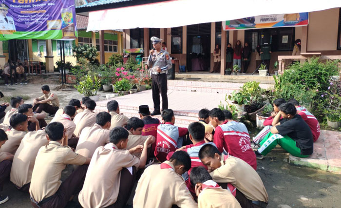 Personel Satlantas Polres Pelalawan saat memberika edukasi tertib berlalu lintas ke pelajar di Ukui, Jumat (15/11/2024).