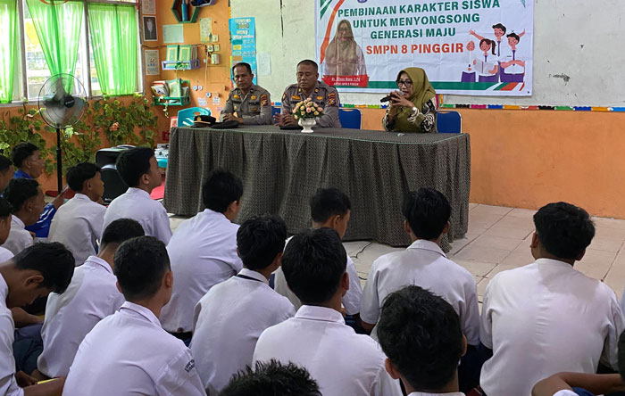 Personel Polsek Pinggir melakukan pembinaan siswa agar berprilaku baik dan turut menyukseskan Pilkada serentak di SMPN 8 Pinggir, Bengkalis, Kamis (14/11/2024).