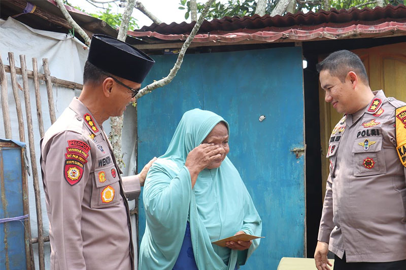 Kapolres Pelalawan AKBP Afrizal Asri dan Dirpamobvit Polda Riau Kombes Pol Wendri Purbyanto saat menyerahkan bantuan sosial kepada seorang warga, Jumat (15/11/2024).