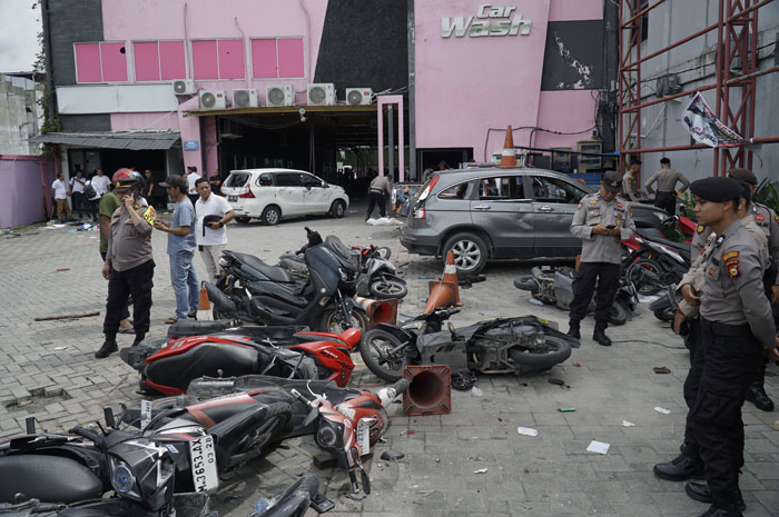 Petugas kepolisian memriksa lokasi pengrusakan kendaraan.