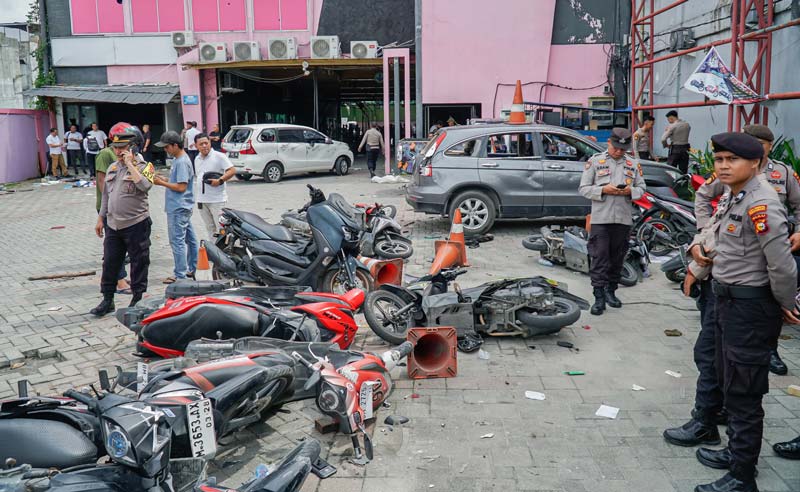 Polisi berjaga-jaga di lokasi tempat usaha cucian mobil (car wash) di Jalan Tuanku Tambusai yang diserang ormas hingga menyebabkan puluhan kendaraan bermotor rusak