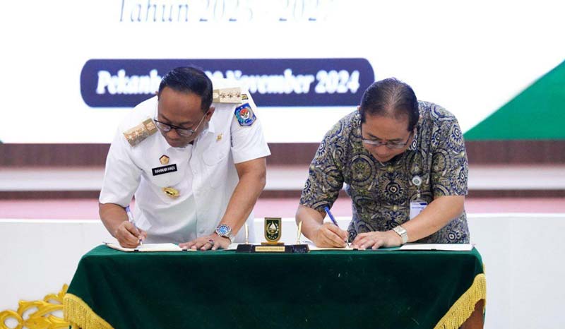 Pj Gubernur Riau Rahman Hadi (kiri) bersama Deputi Direksi Wilayah II BPJS Kesehatan Eddy Sulistijantoe Hadie (kanan) saat menandatangani MoU terkait program JKN
