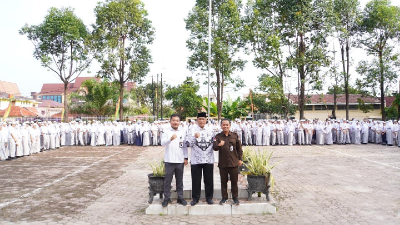 KPU Riau foto bersama Kepala SMAN 8 Pekanbaru dan siswa-siswi di halaman sekolah.