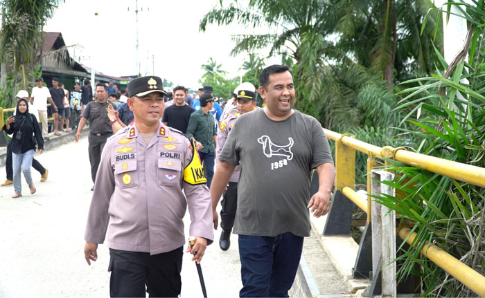 Kapolres Rohul AKBP Budi Setiyono SIK MH didampingi anggota DPRD Riau Dapil Rohul Hardi Chandra saat meninjau kondisi Jembatan Sungai Rokan yang mengalami kemiringan di Desa Suka Damai
