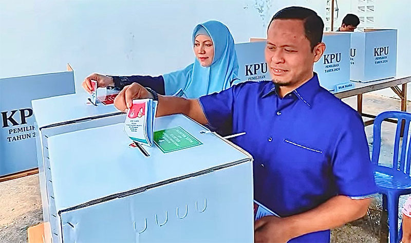 Cawako Pekanbaru nomor urut 5 Agung Nugroho bersama Istri Sulastri saat memasukan surat suara ke korak suara TPS 16, Kelurahan Tobek Godang, Kecamatan Bina Widya, Pekanbaru, Rabu (27/11/2024).
