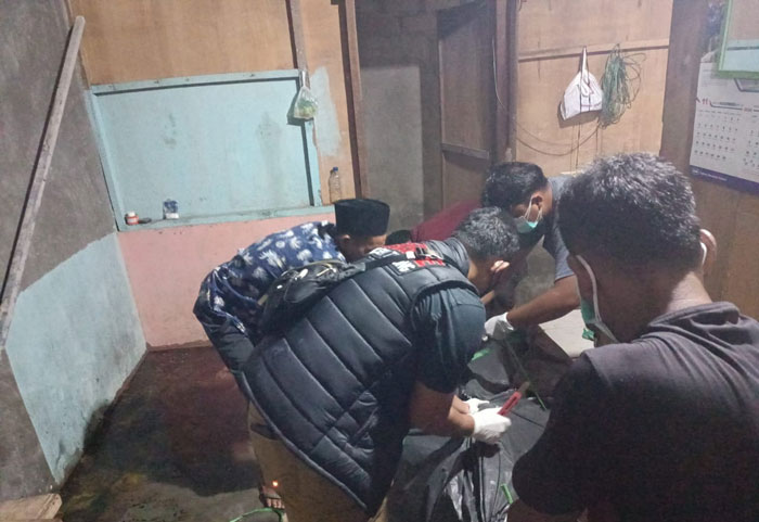 Polisi mengevaluasi jenazah Harunsyah di rumah di Desa Tanjung Sawit, Kecamatan Tapung.