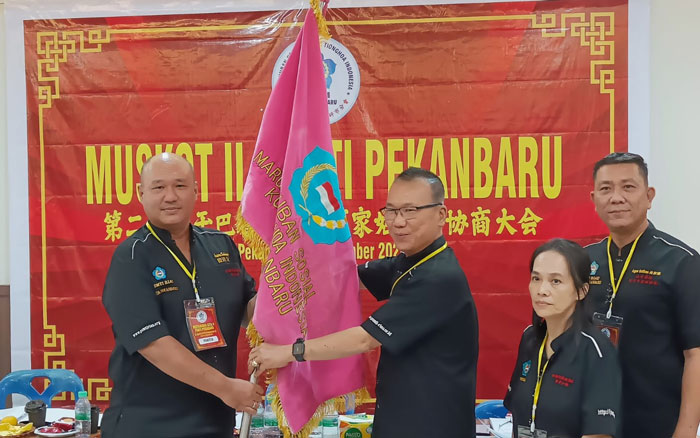 Sebestianus Happy Subagio (kanan) terima pataka dari panitia Muskot PSMTI Kota Pekanbaru usai  terpilih sebagai Ketua PSMTI Kota Pekanbaru periode 2024-2028 usia Muskot PSMTI Kota Pekanbaru.