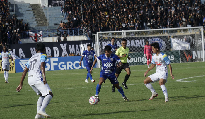 Pemain PSP Pekanbaru, Ilham Fatoni, melewati hadangan pemain Persikota, pada laga PSPS Pekanbaru (biru) menghadapi PERSIKOTA (putih), di Stadion Kaharudin Nasution Rumbai, Ahad (1/12/2024).