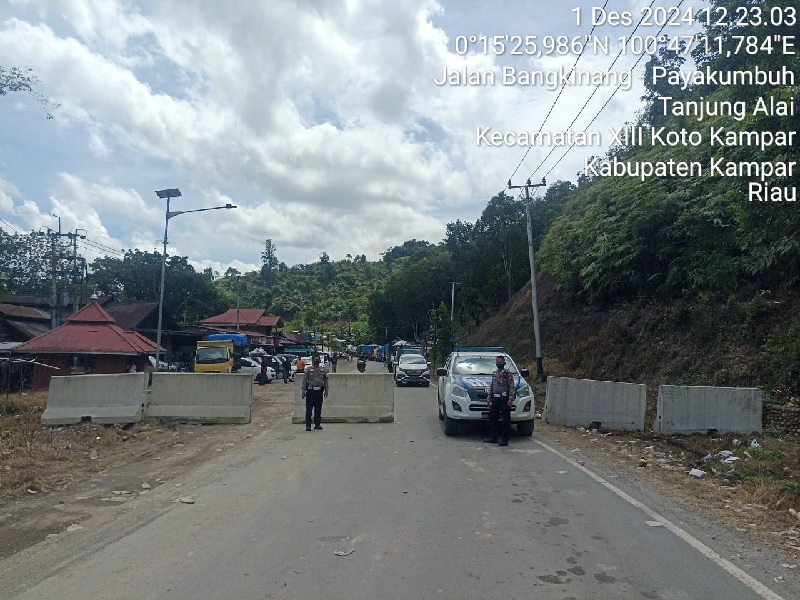 Personsel Polres Kampar menutup jalan lintas Riau-Sumbar km 106-107 Desa Tanjung Alai, Kecamatan XIII Koto Kampar, Kabupaten Kampar, Ahad (1/12/2024).