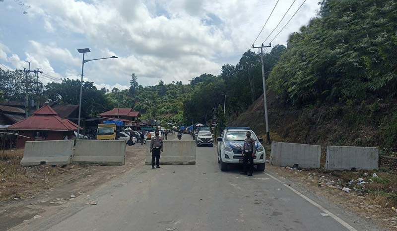 Personsel Polres Kampar memasang beton pembatas di jalan lintas Riau-Sumbar Km 106-107 Desa Tanjung Alai, Kecamatan XIII Koto Kampar
