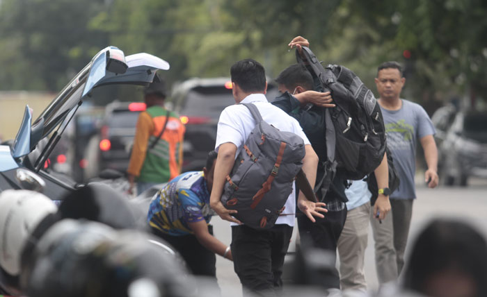 Terlihat ada tiga orang yang membawa tas ransel dan koper tiba di Mapolresta Pekanbaru turun dari taksi, Selasa (3/12/2024).