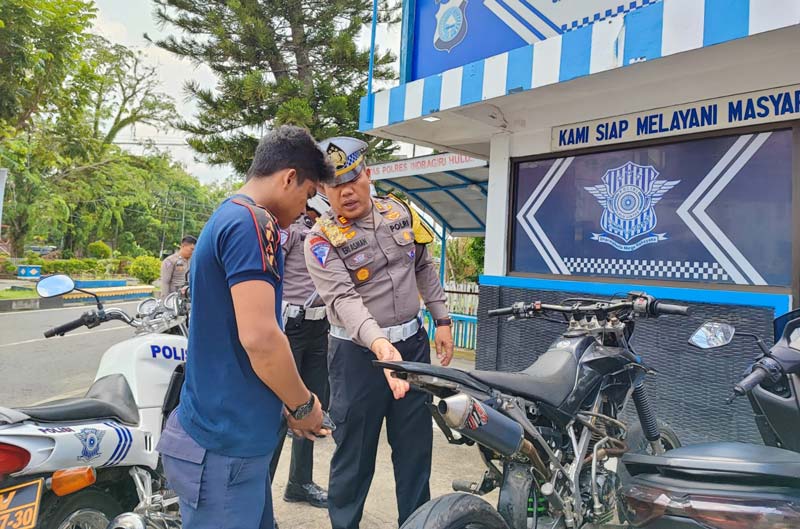 Kasat Lantas Polres Inhu, AKP Eri Asman SH memperlihatkan sebuah kendaraan yang menggunakan knalpot brong hasil penertiban, Selasa (3/12/2024).