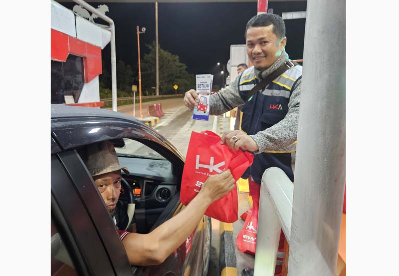 Petugas PT Hutama Karya (Persero) saat memberikan bingkisan kepada pengguna Jalan Tol di Gerbang Tol Bathin Solapan,  Selasa (3/12/2024).