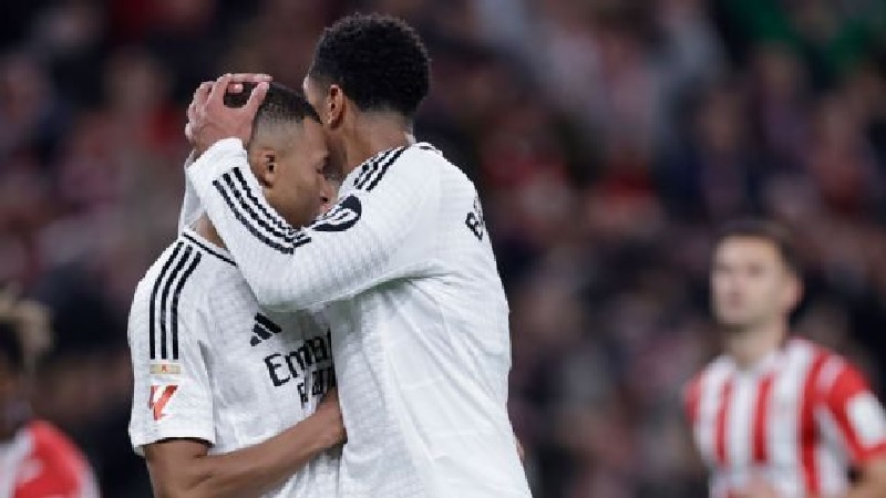 Pemain Real Madrid Jude Bellingham (kanan) menghibur rekan setimnya Kylian Mbappe setelah gagal mengeksekusi penalti saat kalah 1-2 dari Athletic Bilbao di San Mames, Kamis (5/12/2024).