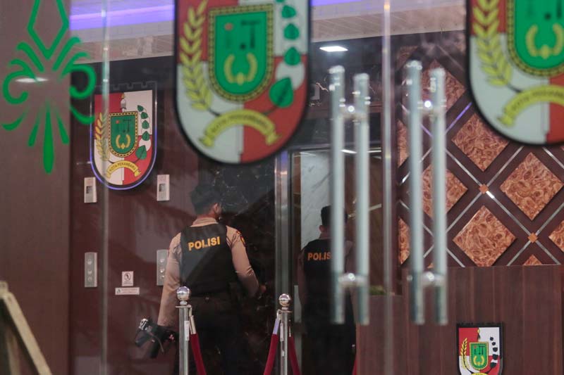 Petugas kepolisian mengawal penggeledahan yang dilakukan penyidik KPK di Gedung Utama Kantor Wali Kota Pekanbaru Kompleks Perkantoran Tenayan Raya, Pekanbaru, Kamis (5/12/2024).