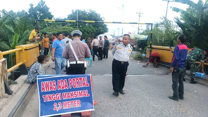 Petugas Dishub Rohul dan Satlantas Polres Rohul, Polsek Ujung Batu  dibantu  masyarakat desa setempat memasang Portal di Jembatan Sungai Rokan, Rohul