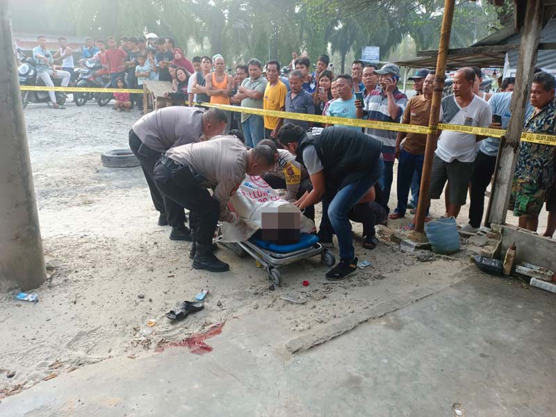 Petugas kepolisian bersama tim medis melakukan evakuasi jasad korban pembunuhan di halaman depan rumah kontrakan di Jalan Lintas Duri-Pekanbaru