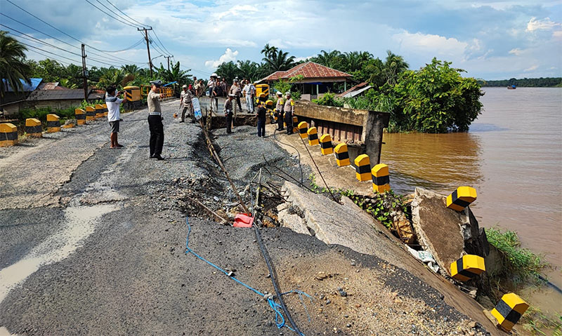 Ditlantas Polda Riau bersama personel Polres Inhu meninjau badan jalan Rengat-Tembilahan yang longsor akibat abrasi Sungai Indragiri, Kamis (12/12/2024).