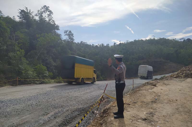 Personel Satlantas Polres Kampar mengatur lalu lintas di jalan lintas Riau-Sumbar Km 106-107 Desa Tanjung Alai, Kecamatan XIII Koto Kampar