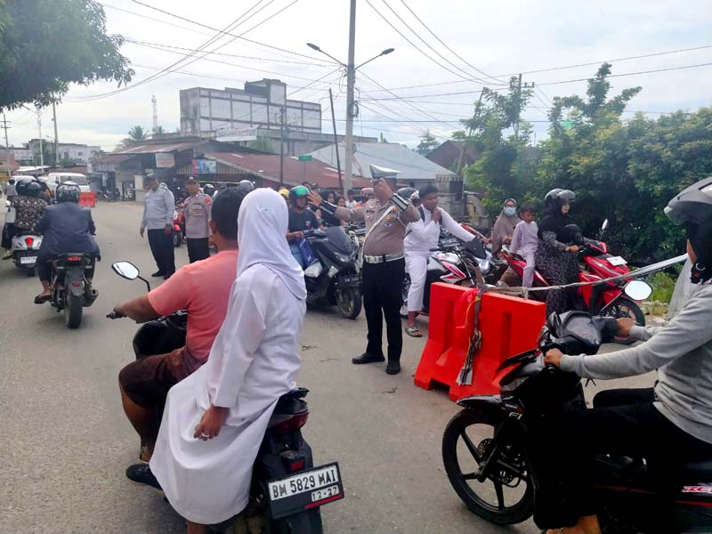 Personel Satuan Lalu Lintas Polres Rohul bersama Dishub Rohul mengatur arus lalu lintas di Pos Pantau dan sistem buka tutup di Jembatan Sungai Rokan