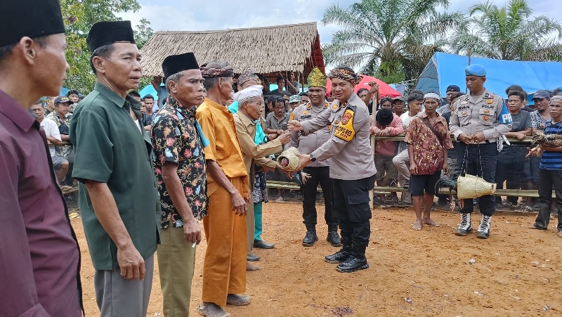 Wakapolres Inhu, Kompol Manapar Situmeang SIK MH menyerahkan ayam jantan kepada Batin Bangka pada acara Gawai Kebatin, belum lama ini.