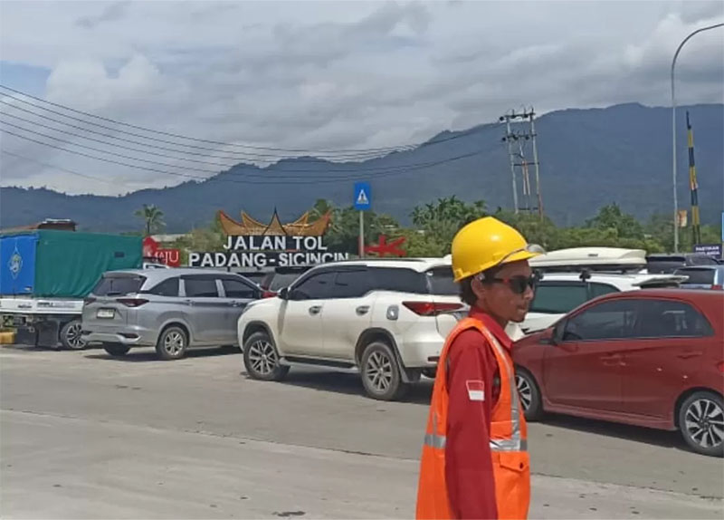 Petugas mengatur antrean kendaraan masyarakat yang antusias ingin mencoba melintasi tol Padang Sicincin, Ahad (15/12/2024).
