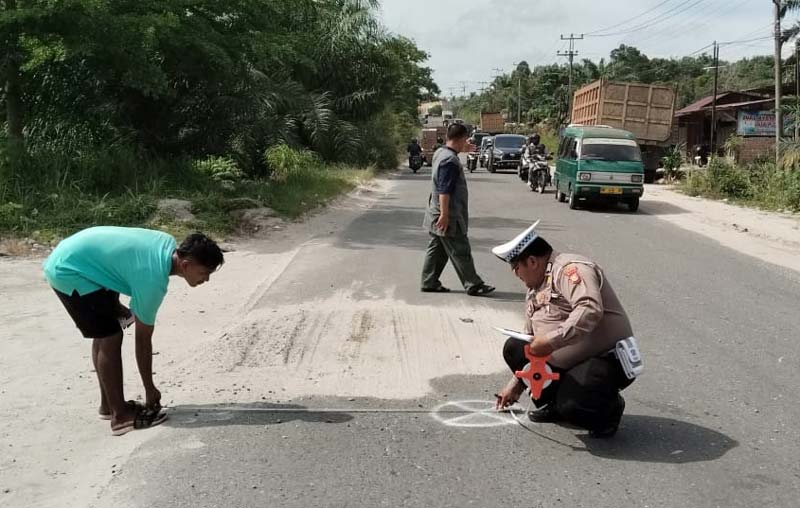Personel Satlantas Polres Kampar melakukan olah TKP kecelakaan lalu lintas di Jalan Garuda Sakti- Petapahan, KM 6 Desa Karya Indah, Kecamatan Tapung, Kabupaten Kampar, Ahad (15/12/2024).