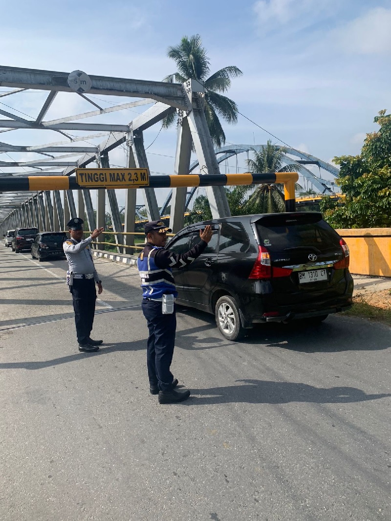 Petugas Dishub Kampar mengatur arus lalu lintas di jembatan penghubung Bangkinang-Petapahan yang dipasang portal, Selasa (17/12/2024).