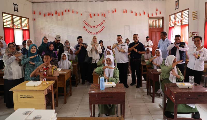 Asisten III Sekretariat Daerah Kabupaten Siak Rozi Candra dan manajemen PTPN IV Regional III foto bersama dengan siswa pada acara makan gratis bergizi