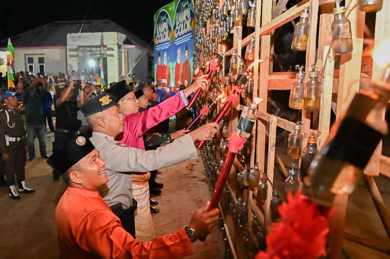 Asisten Perekonomian dan Pembangunan Setkab Bengkalis Toharudin (tiga kiri) menyalakan lampu colok pada malam pergelaran lampu colok