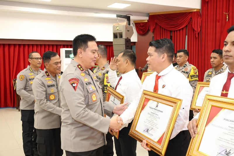 Kapolda Riau Irjen Pol Mohammad Iqbal menyerahkan penghargaan kepada salah satu personel berprestasi, Senin (23/12/2024).