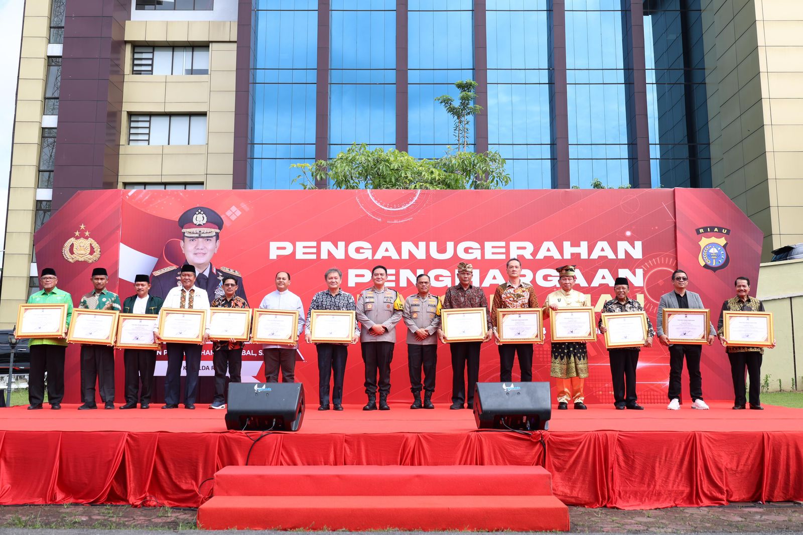 Kapolda Riau Irjen Pol Mohammad Iqbal berfoto bersama pejabat dan tokoh masyarakat yang menerima penghargaan di Halaman Mapolda Riau, Selasa (24/12/2024).