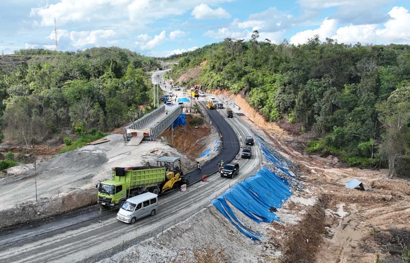 Pekerja melakukan pengaspalan jalan lintas Riau-Sumbar di Km 106-107 Desa Tanjung Alai, Kecamatan XIII Koto Kampar, Kabupaten Kampar, Rabu (25/12/2024).