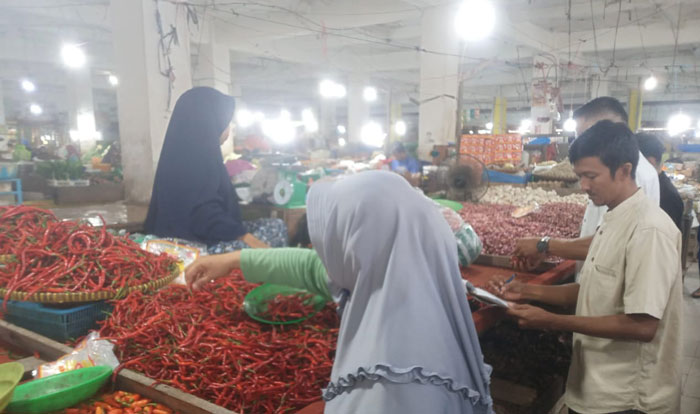 Petugas Disperindag Kabupaten Inhu saat melakukan pengecekan harga di pasar rakyat Kota Rengat, Jumat (27/12/2024)