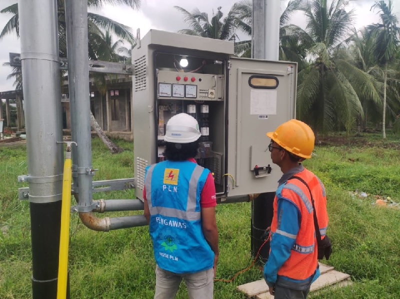 Petugas PLN melakukan pengecekan listik di Desa Pengaliran Indragiri Hikir yang kini bisa menikmati aliran listrik PLN 24 jam.