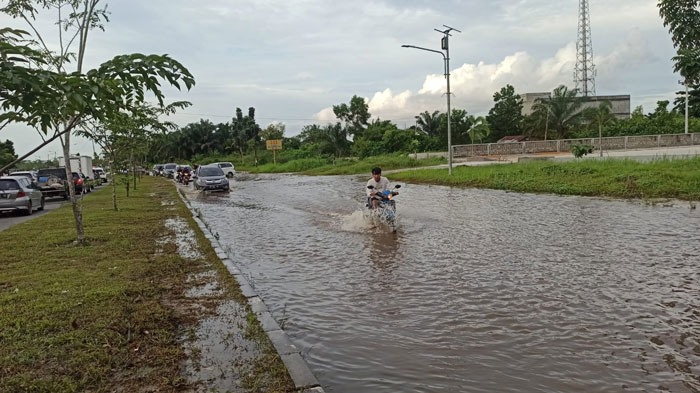 Kendaraan roda dua terlihat menerobos banjir di Jalan Sudirman Ujung Kota Pekanbaru, Senin (30/12/2024) sore.