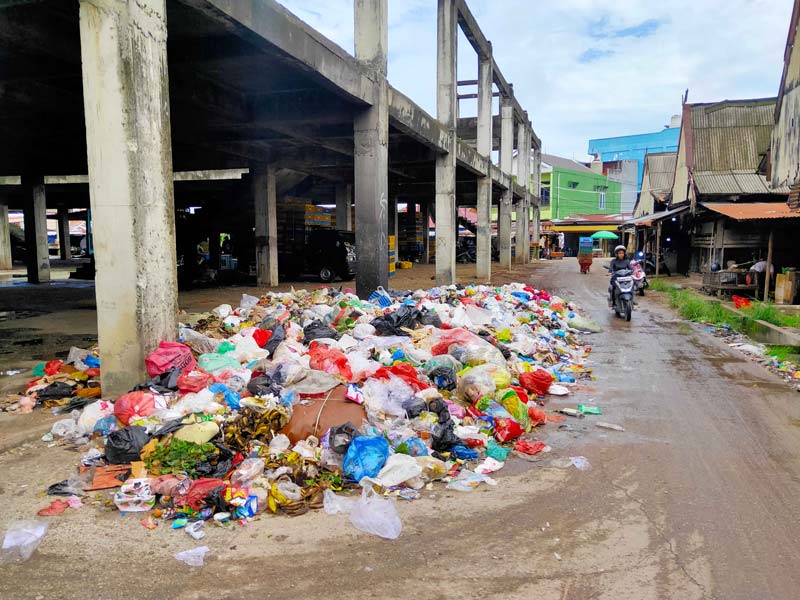 Kondisi sampah yang berserakan dan menumpuk hingga menutupi sebagian jalan di kawasan Pasar Cik Puan, Jalan Tuanku Tambusai, Pekanbaru, Senin (30/12/2024).