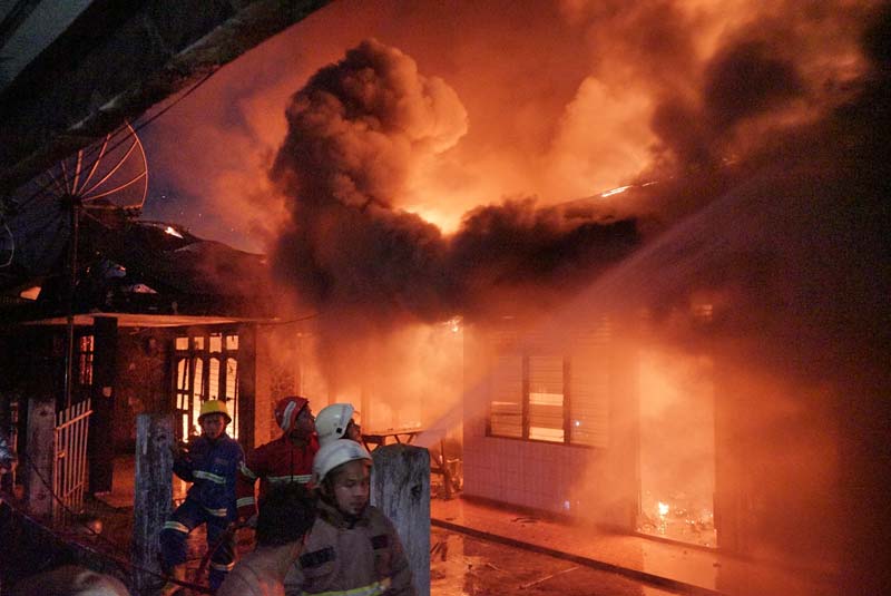 Petugas pemadam kebakaran Pekanbaru berusaha memadamkan api yang membakar rumah di Jalan Agus Salim, Kecamatan Pekanbaru Kota, Rabu (1/1/2025) dini hari.