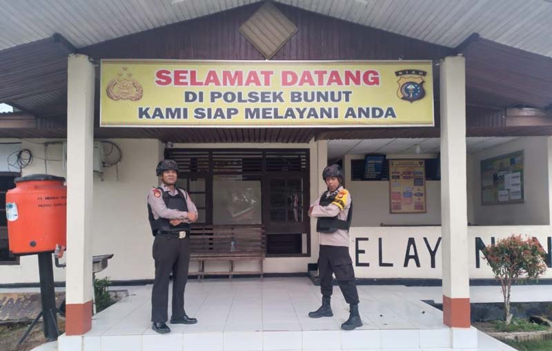 Dua petugas berpose di depan Mapolsek Bunut, beberapa waktu lalu.