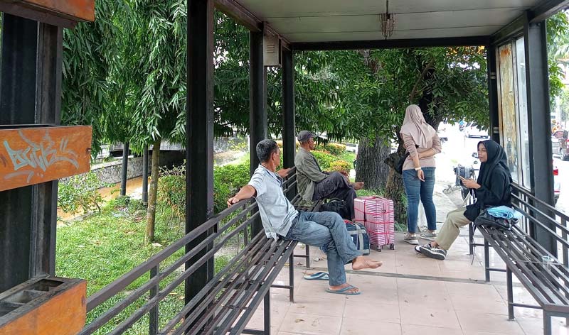 Calon penumpang menunggu kedatangan bus TMP di halte depan Gelanggang Remaja, Jalan Jenderal Sudirman, Pekanbaru, Jumat (3/1/2025).