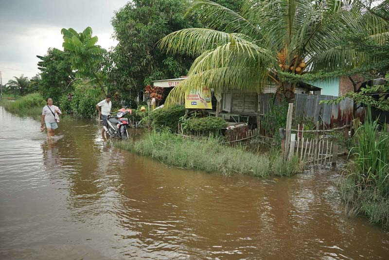 Warga tetap beraktivitas di tengah banjir Sungai Siak yang merendam wilayah Kelurahan Kampung Baru, Kecamatan Senapelan, Ahad (5/1/2025).